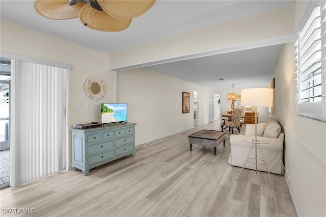 living room with a ceiling fan and light wood-type flooring