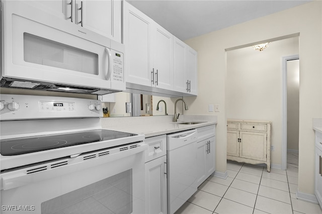 kitchen featuring white appliances, light tile patterned flooring, a sink, light countertops, and white cabinetry