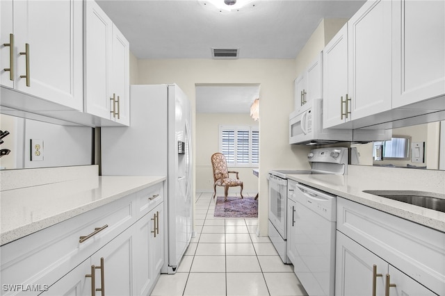 kitchen with white appliances, light tile patterned floors, light stone countertops, visible vents, and white cabinetry