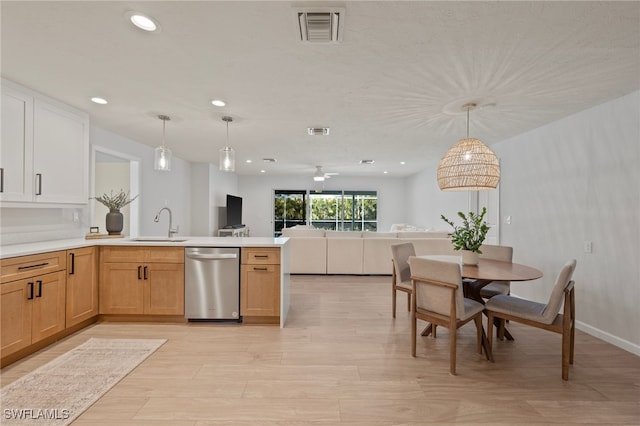 kitchen featuring visible vents, a peninsula, a sink, stainless steel dishwasher, and open floor plan