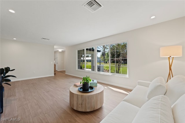 living area featuring baseboards, recessed lighting, visible vents, and light wood-type flooring