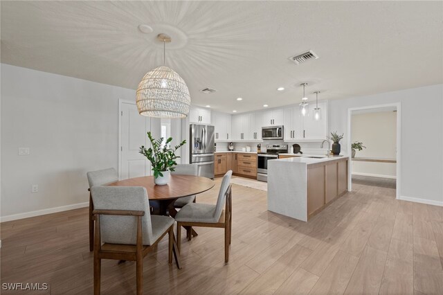 dining space featuring light wood finished floors, visible vents, recessed lighting, and baseboards