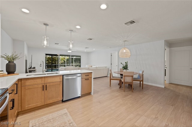 kitchen with a sink, light wood-style flooring, appliances with stainless steel finishes, and open floor plan