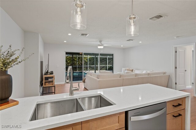 kitchen with stainless steel dishwasher, open floor plan, and visible vents