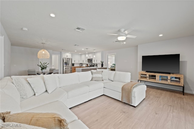 living room with visible vents, light wood-style flooring, a ceiling fan, recessed lighting, and baseboards