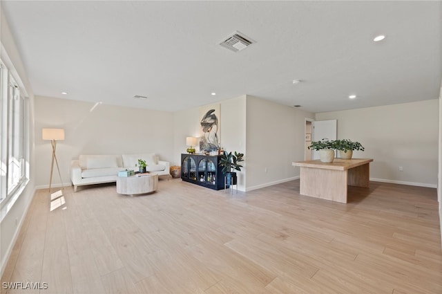 living area with recessed lighting, visible vents, baseboards, and light wood finished floors