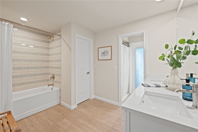 bathroom with shower / bath combo, wood finished floors, recessed lighting, baseboards, and vanity