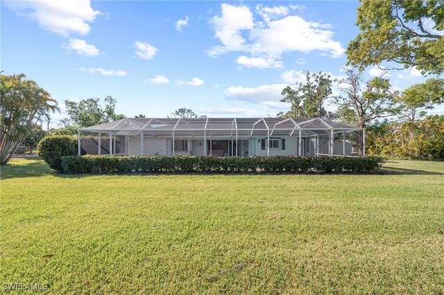 back of house with glass enclosure, a yard, and stucco siding