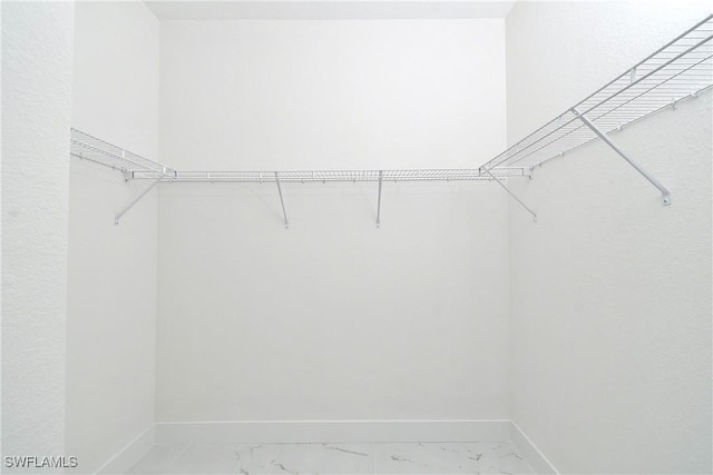 spacious closet featuring marble finish floor