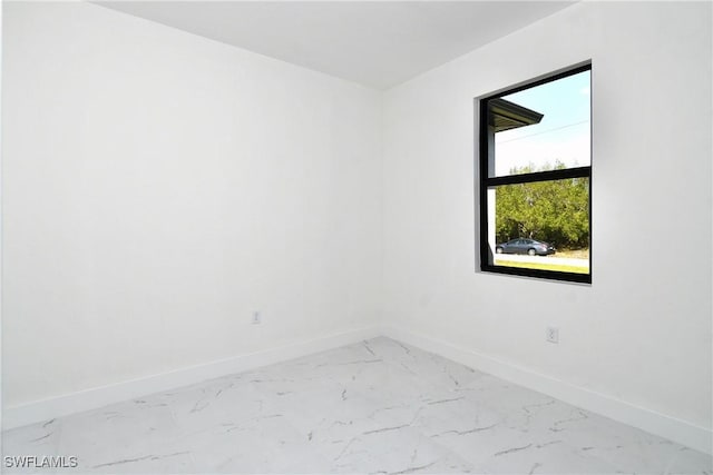 empty room with baseboards and marble finish floor