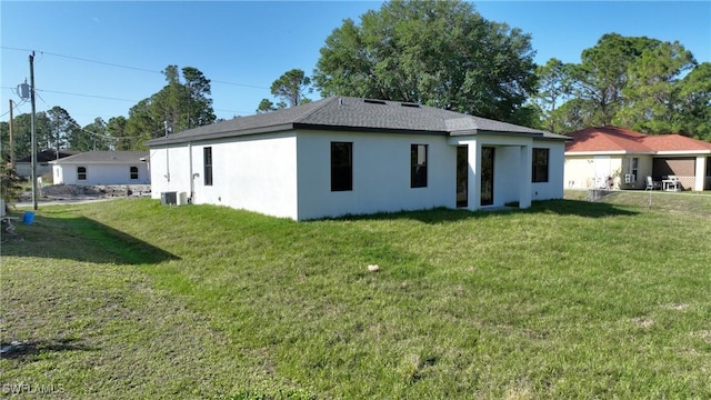 2810 64th St W, Lehigh Acres, FL 33971 - back of property with stucco siding, central air condition unit, and a lawn