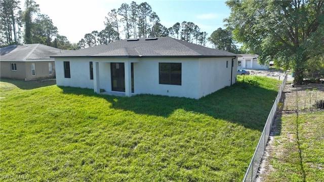 2810 64th St W, Lehigh Acres, FL 33971 - rear view of house with a lawn, stucco siding, and fence