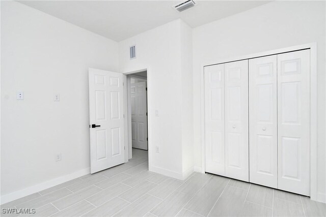 2810 64th St W, Lehigh Acres, FL 33971 - unfurnished bedroom featuring a closet, baseboards, and visible vents