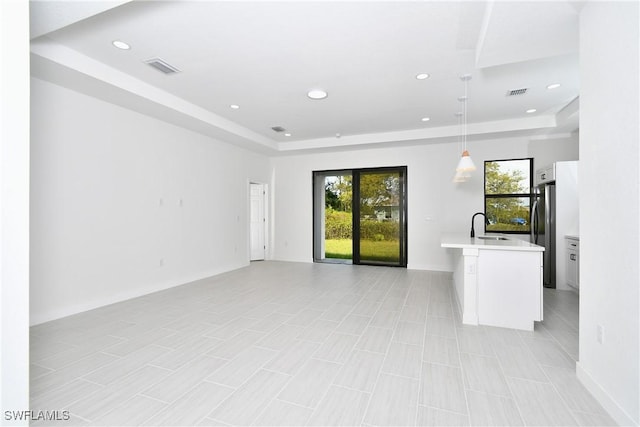 2810 64th St W, Lehigh Acres, FL 33971 - unfurnished living room with a tray ceiling, a sink, visible vents, and recessed lighting