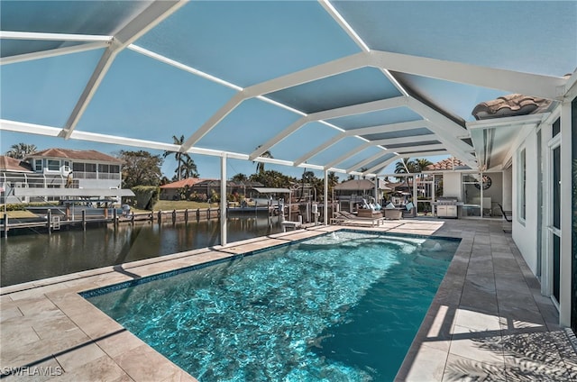 pool with glass enclosure, a patio area, a water view, and a boat dock