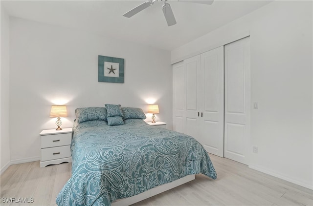 bedroom with wood finished floors, a closet, baseboards, and ceiling fan