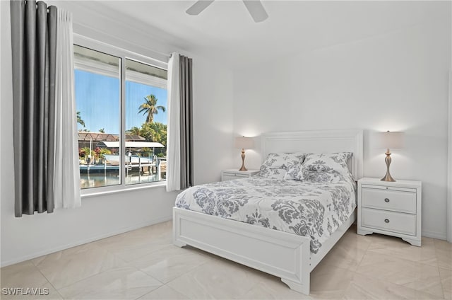 bedroom with baseboards, ceiling fan, and light marble finish floors