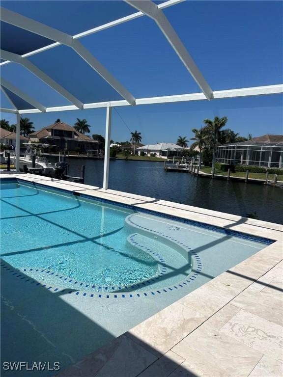 pool with a water view, a patio, and glass enclosure