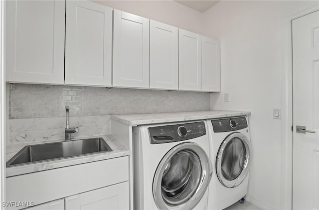 clothes washing area with cabinet space and washing machine and clothes dryer