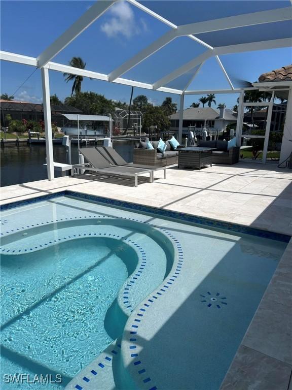 outdoor pool featuring outdoor lounge area, a patio, a boat dock, and glass enclosure
