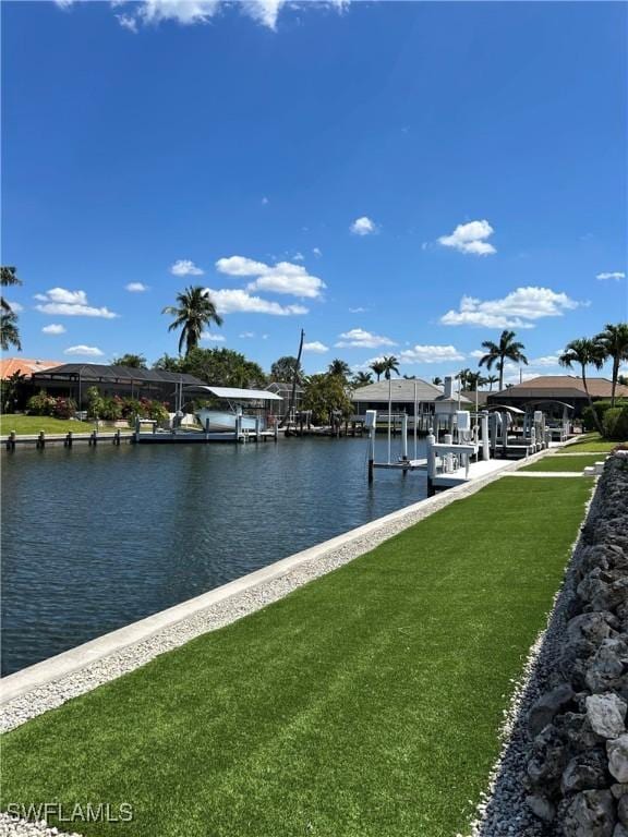 dock with boat lift, a water view, and a lawn