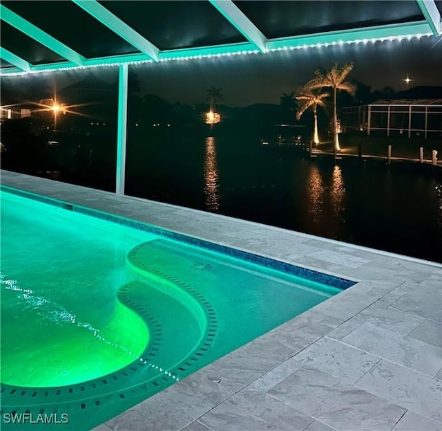 pool at twilight featuring an outdoor pool and a patio