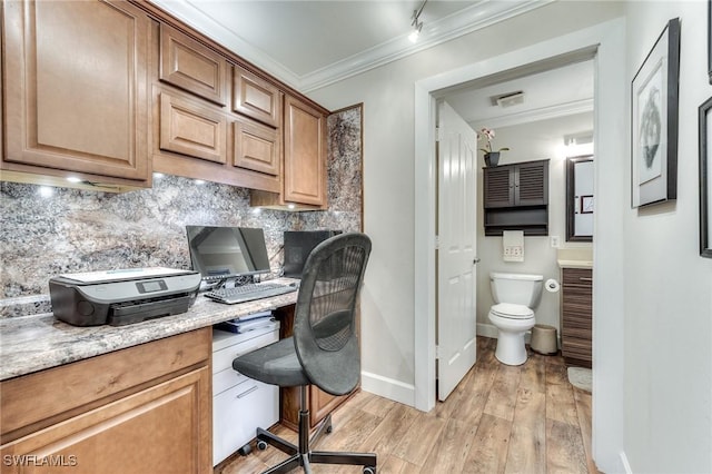 office featuring crown molding, baseboards, built in desk, and light wood finished floors