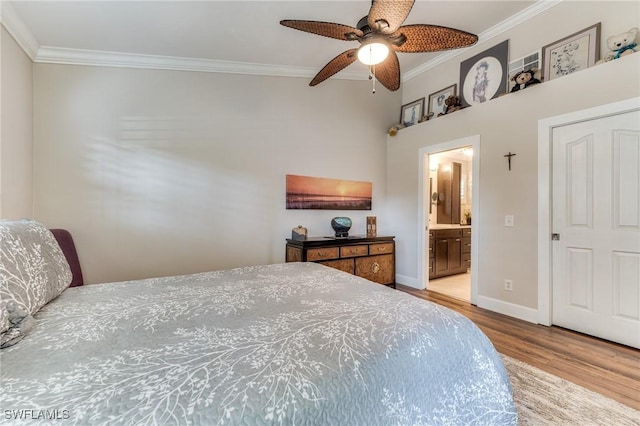 bedroom featuring connected bathroom, crown molding, baseboards, wood finished floors, and a ceiling fan