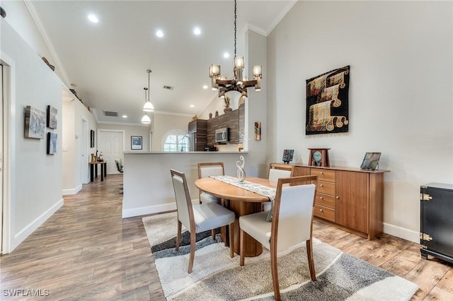 dining room featuring crown molding, baseboards, visible vents, and light wood finished floors