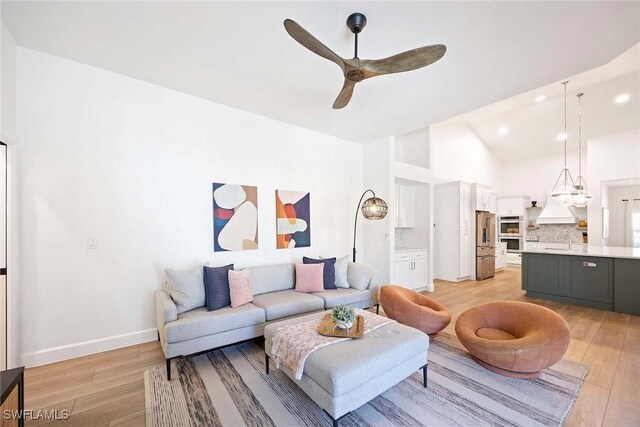 living area with high vaulted ceiling, recessed lighting, light wood-style floors, baseboards, and ceiling fan