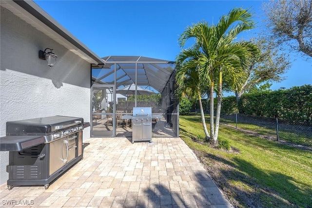 view of patio / terrace with a lanai, area for grilling, and fence