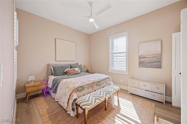 bedroom featuring ceiling fan, baseboards, and light wood-style floors