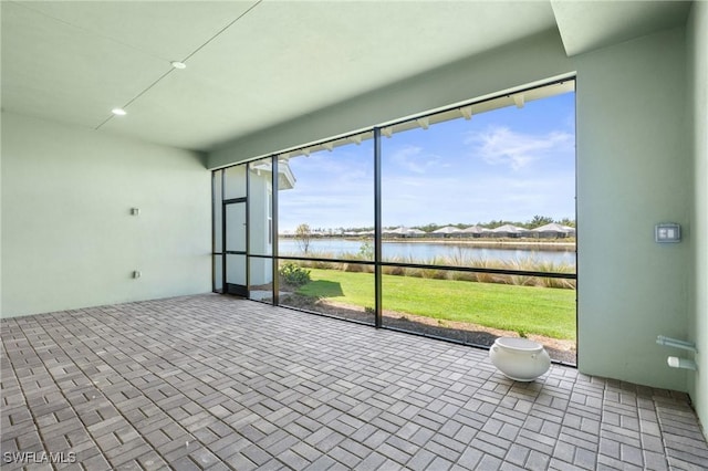 unfurnished sunroom with a water view