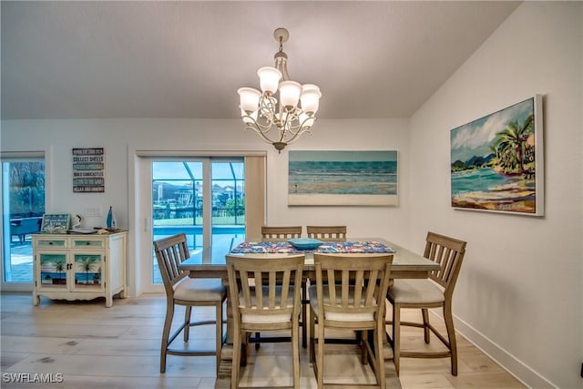 dining space with baseboards, an inviting chandelier, and wood finished floors