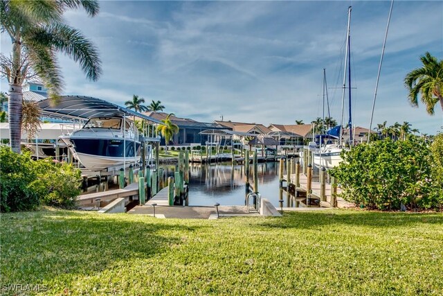dock area featuring a yard, a water view, boat lift, and a residential view
