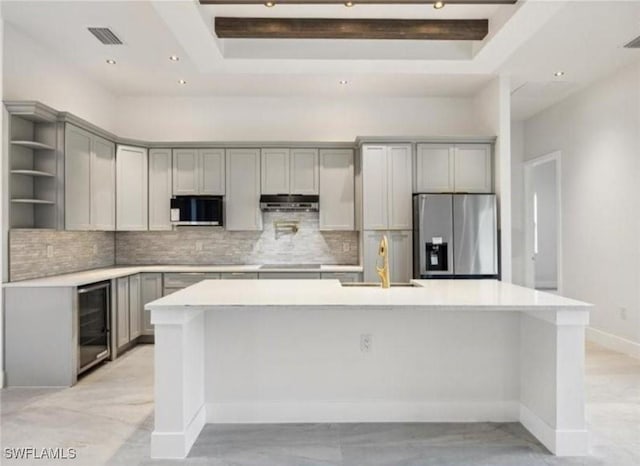 kitchen featuring a sink, stainless steel fridge, gray cabinets, and open shelves