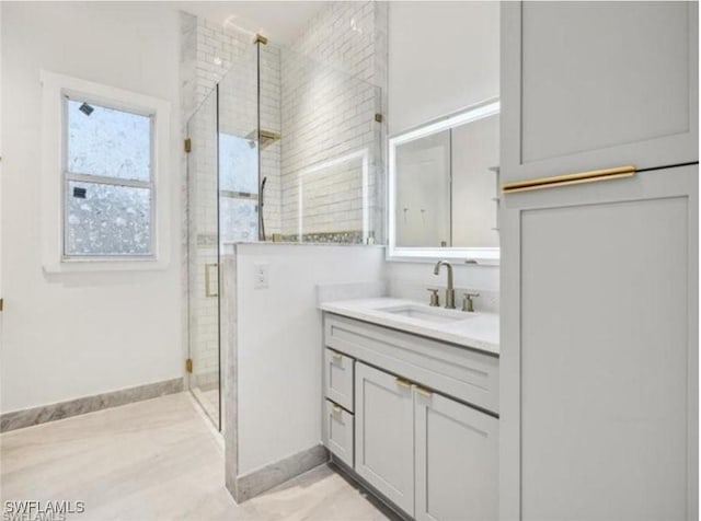 full bathroom featuring a stall shower, vanity, and baseboards