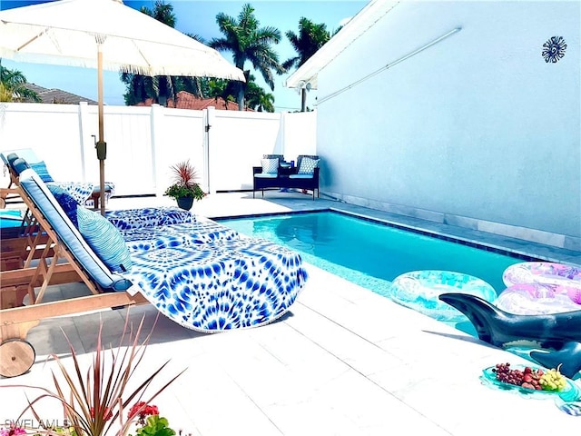 view of swimming pool with a fenced in pool, a patio, and fence