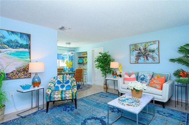 living room featuring visible vents, baseboards, and a textured ceiling