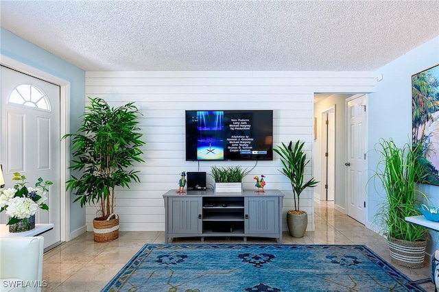 living area with a textured ceiling and tile patterned flooring