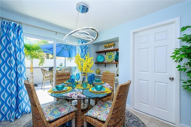 dining space featuring light tile patterned floors, a chandelier, and a textured ceiling