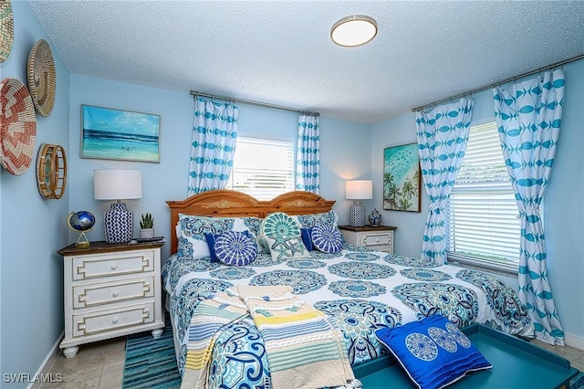 bedroom with baseboards and a textured ceiling