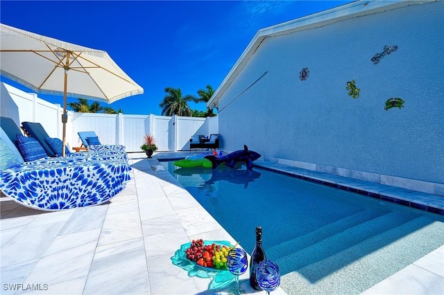 view of pool featuring a patio area and a fenced backyard