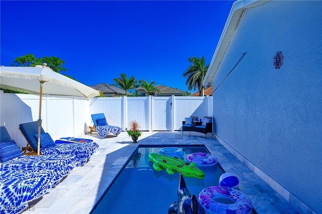 view of pool with a fenced backyard and a patio