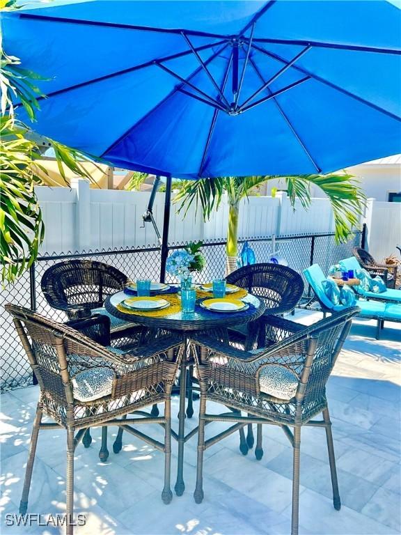 view of patio with outdoor dining space and fence