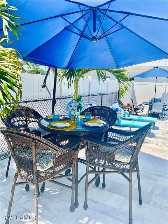 view of patio with outdoor dining space and fence