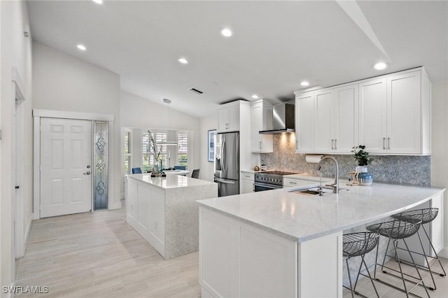 1590 Weybridge Cir Unit 52, Naples, FL 34110 - kitchen featuring a sink, stainless steel appliances, wall chimney exhaust hood, lofted ceiling, and a kitchen island