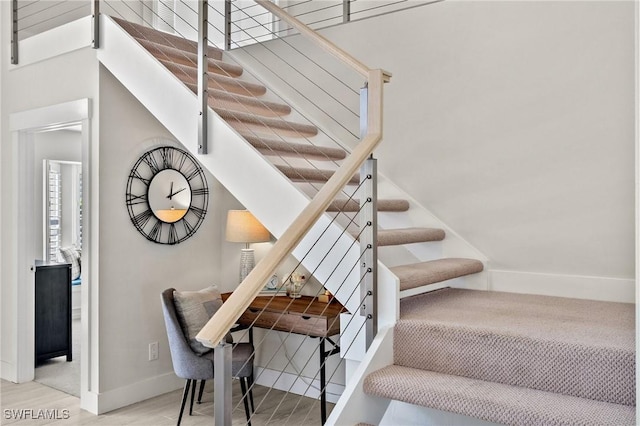 stairway with baseboards and wood finished floors