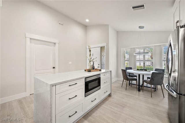 1590 Weybridge Cir Unit 52, Naples, FL 34110 - kitchen with stainless steel appliances, white cabinetry, light wood-style flooring, recessed lighting, and pendant lighting
