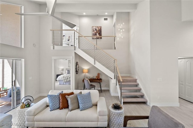 1590 Weybridge Cir Unit 52, Naples, FL 34110 - living room featuring wood finished floors, stairs, baseboards, a towering ceiling, and recessed lighting